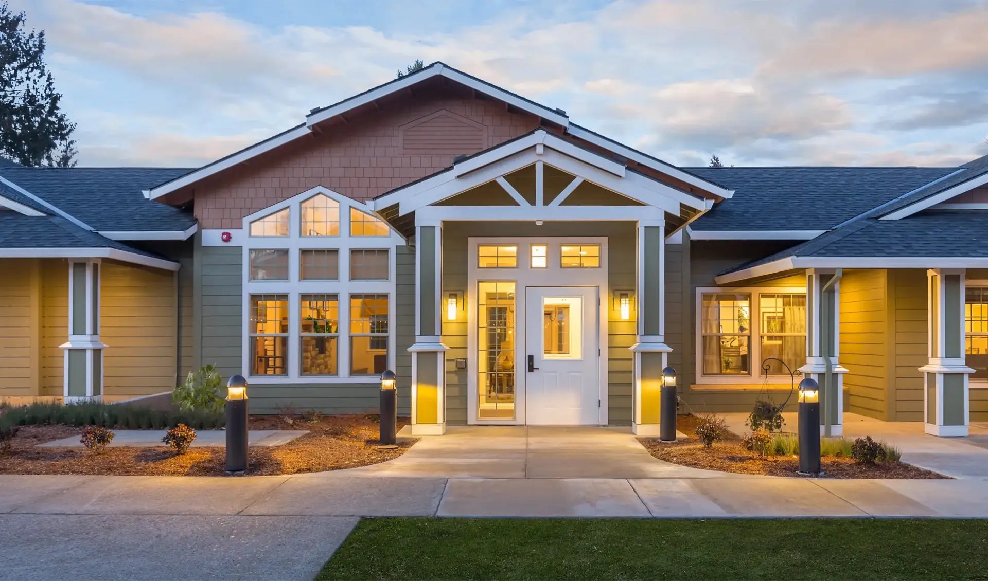 Craftsman home at dusk with exterior and interior lighting on
